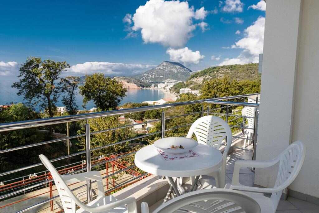 Balcony with table and chairs overlooking the sea in Sutomore